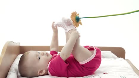 baby playing with a flower trying to take it