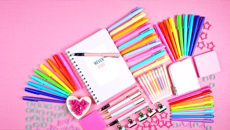 back to school or workspace colorful stationery on pink flatlay stop motion.