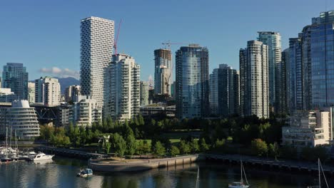 drone aerial intro shot overlooking the vancouver cityscape moving towards several skyscrapers - canada