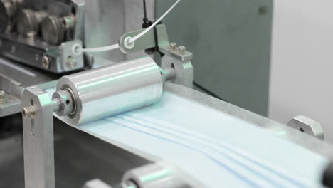máscara protectora de tres capas en la línea de producción con plegado automático de rodillos de acero