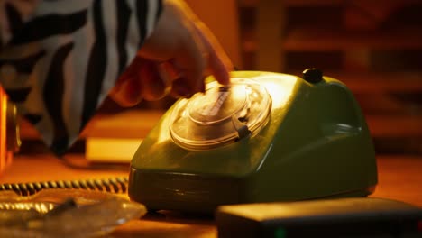 woman dialing an old-fashioned rotary phone