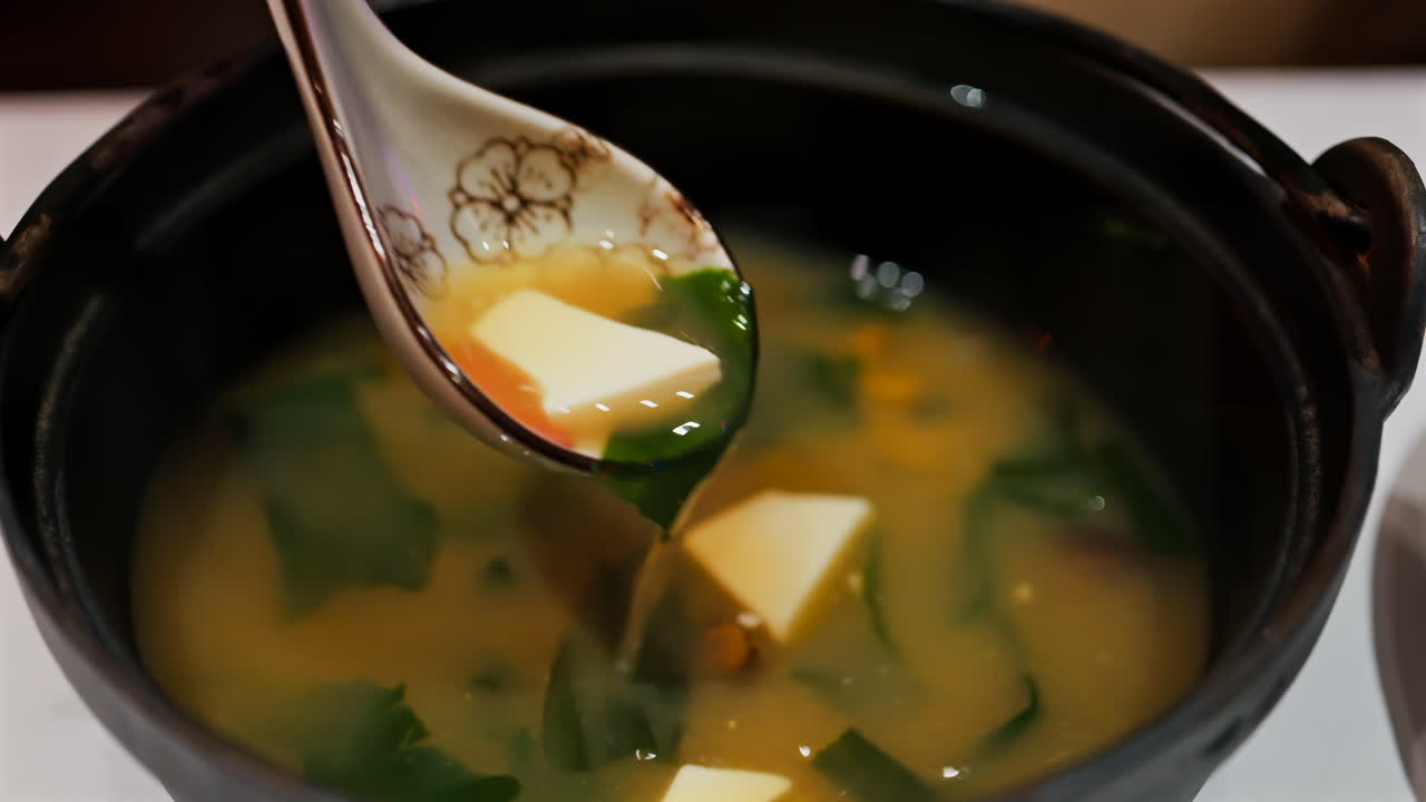 Close up of a woman mixing a miso soup at a restaurant