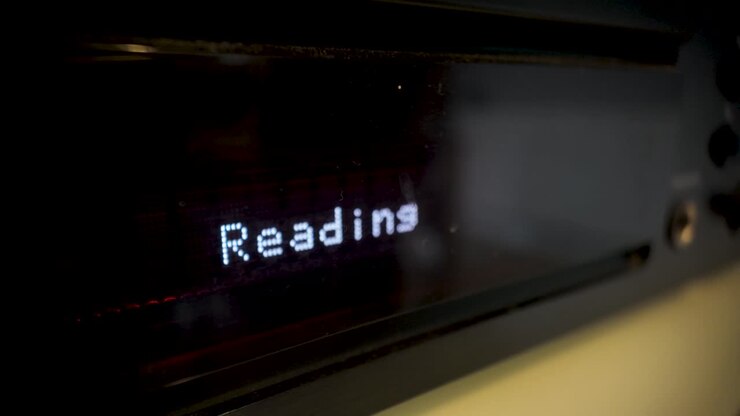 Schermo LCD del lettore CD con scritta "Lettura" durante il caricamento del disco