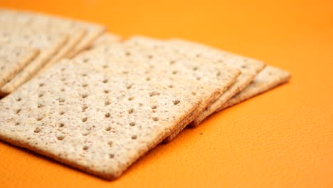 galletas de trigo entero apiladas sobre un fondo naranja