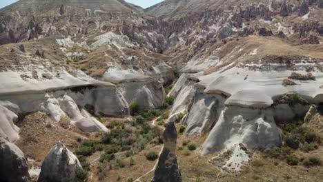 Vista-Aérea-De-Una-Chimenea-De-Hadas-Y-Un-Valle-Rojo-En-Goreme,-Capadocia