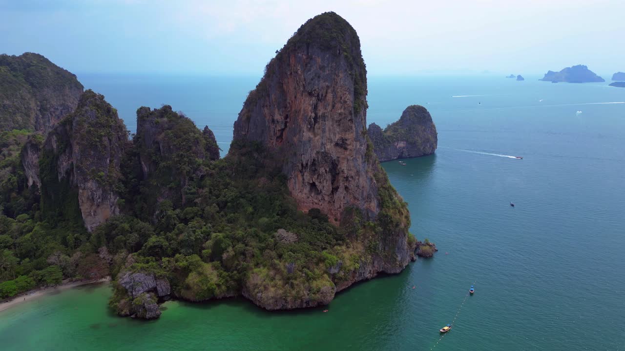 Rock climber resting during a difficult climb on Rai Leh beach cliff in Thailand. Dramatic aerial view flight speed ramp hyper motion time lapse
