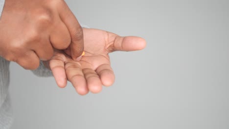 a person's hand holding a pill