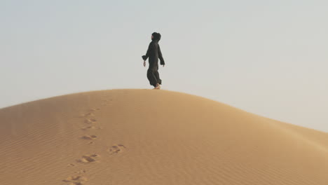 Schöne-Muslimische-Frau-Im-Hijab,-Die-Barfuß-In-Einer-Windigen-Wüste-Läuft