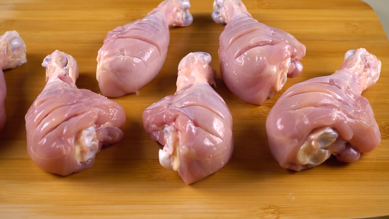 Cosce di pollo fresche su un tagliere
