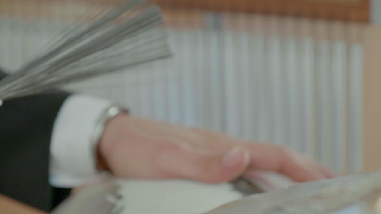 primer plano de un baterista tocando un tambor udu con la mano y sosteniendo un cepillo en la otra, con campanadas de fondo