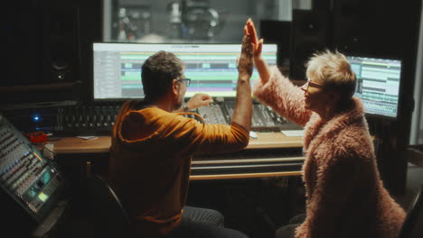 music artist and sound engineer collaborating on audio production in studio