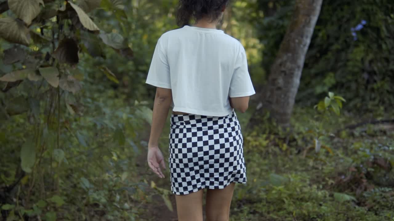 espectáculo cinematográfico en cámara lenta de un modelo alejándose de la cámara en un bosque en goa, india, slomo