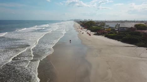 Beautiful-drone-shot-over-beach-and-ocean-with-stunning-waves-and-clouds,-Itanhaem-Brazil