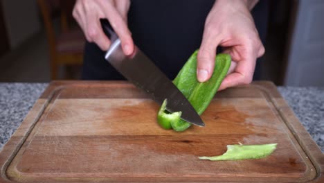 close-up of cook cutting red bell pepper into small cubes or dices