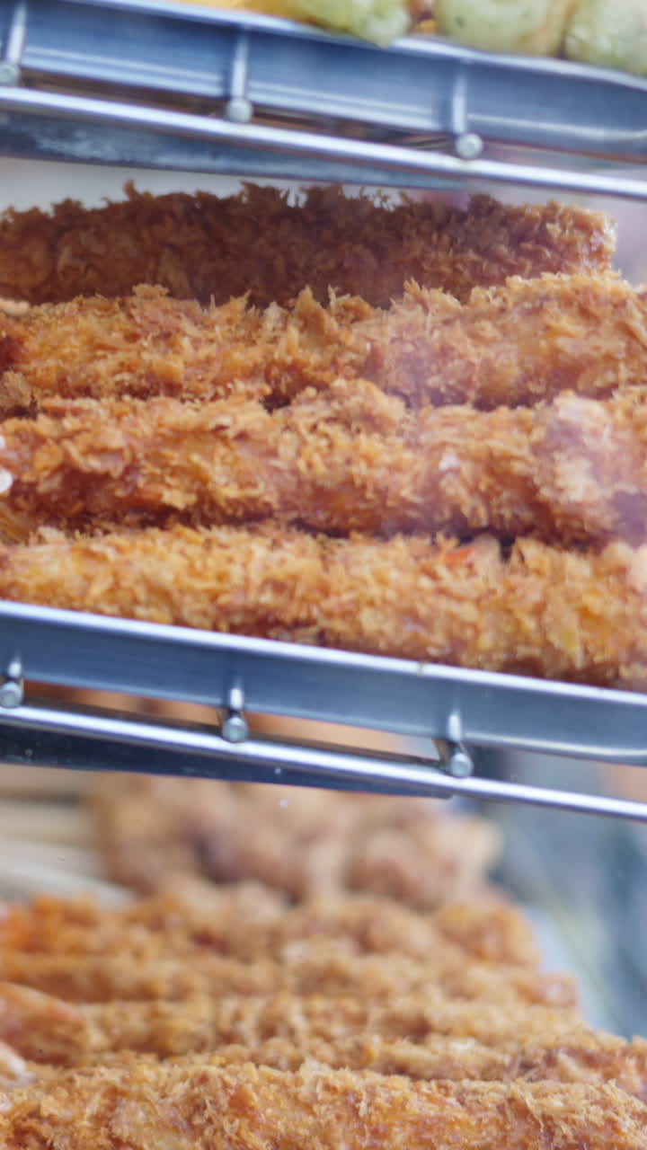 Different types of deep fried seafood on display at the Tsukiji Fish Market in Japan. Vertical