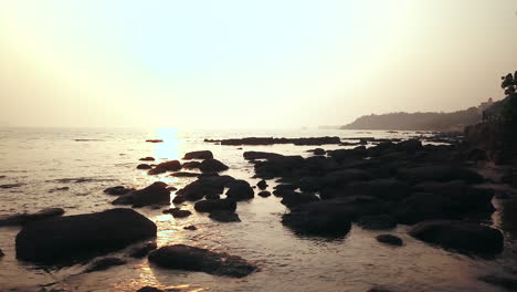 Felsbrocken-Während-Des-Sonnenuntergangs-Am-Strand,-Küste-Von-Goa,-Indien,-Filmischer-Schwenk-Nach-Rechts