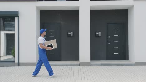 young courier holding a parcel and tablet walking on the street to deliver a box directly to a customer home.