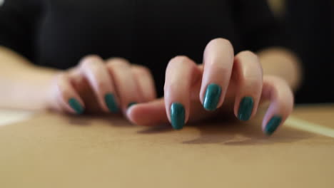 uñas largas femeninas tocando una superficie dura