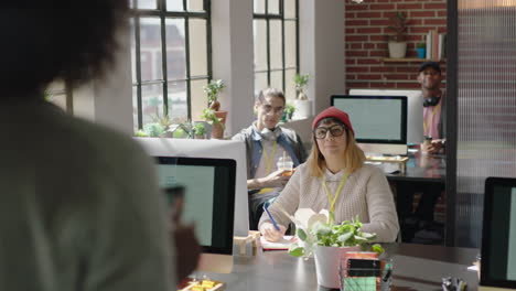 Gente-De-Negocios-Reuniéndose-Con-Una-Líder-De-Equipo-Afroamericana,-Una-Mujer-Informando-Al-Equipo-Compartiendo-Comentarios,-Colegas-Discutiendo-El-Proyecto-De-Inicio-En-Un-Lugar-De-Trabajo-Moderno.