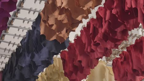 colourful tanned hides drying on a moving drying rack in a leather and textiles plant