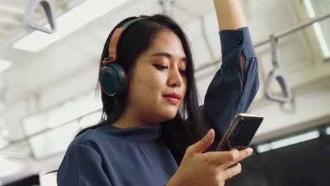 young woman using mobile phone on public train