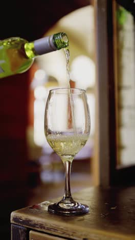 pouring white wine into a glass