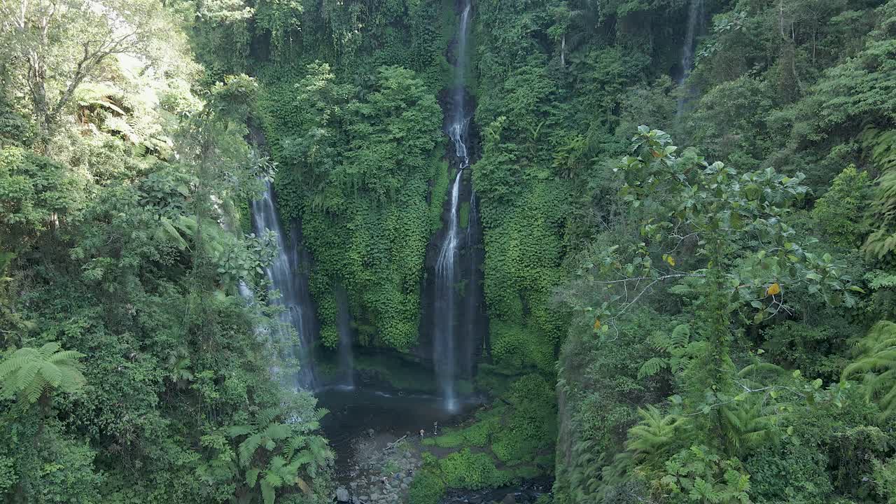 Aerial approaches beautiful natural waterfall, dense lush Bali jungle