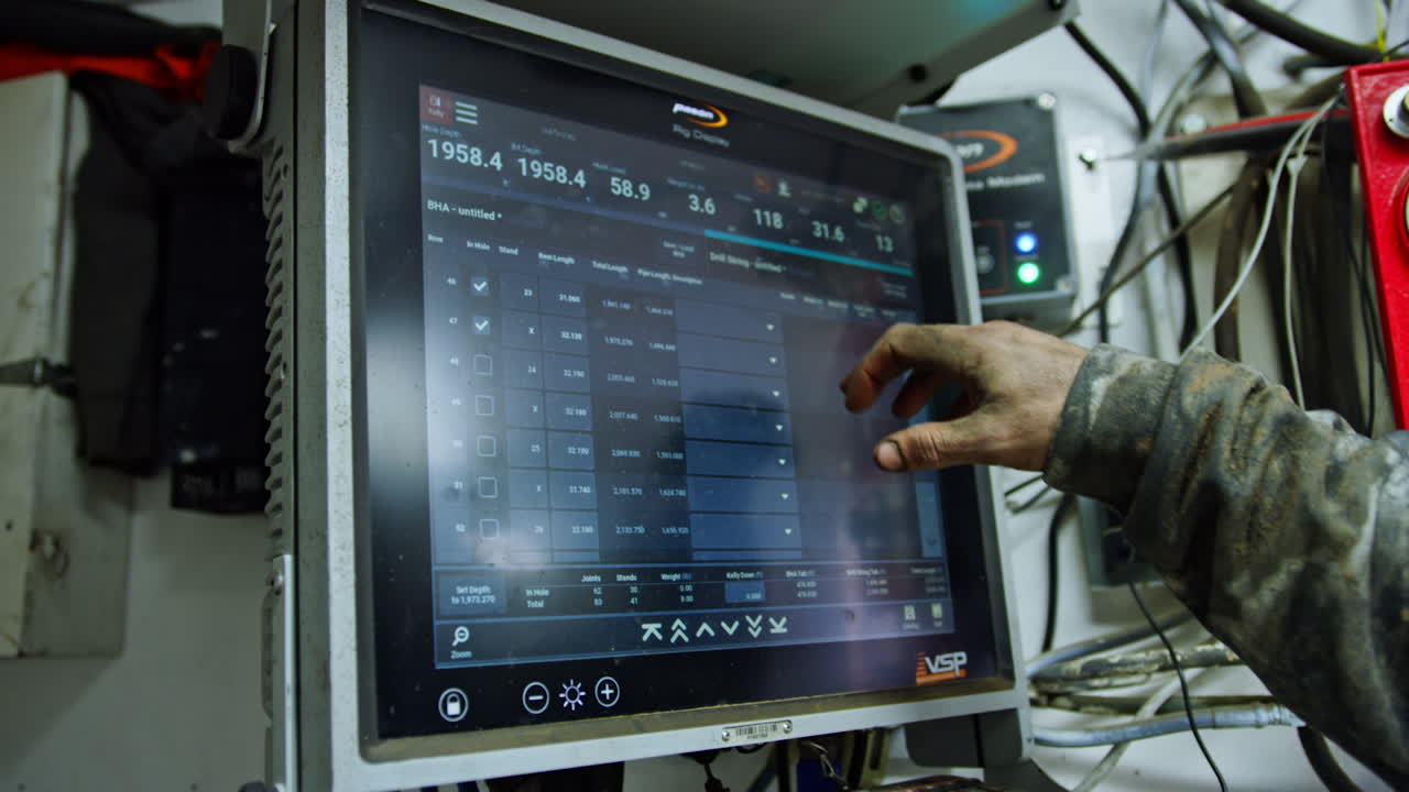 Dirty male hand pressing the keys on the touch screen of computer equipment. Arranging the work of equipment at oil production site.