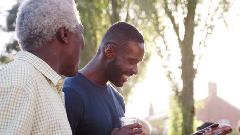 Grandad-talks-with-his-sons-and-grandson-at-family-barbecue