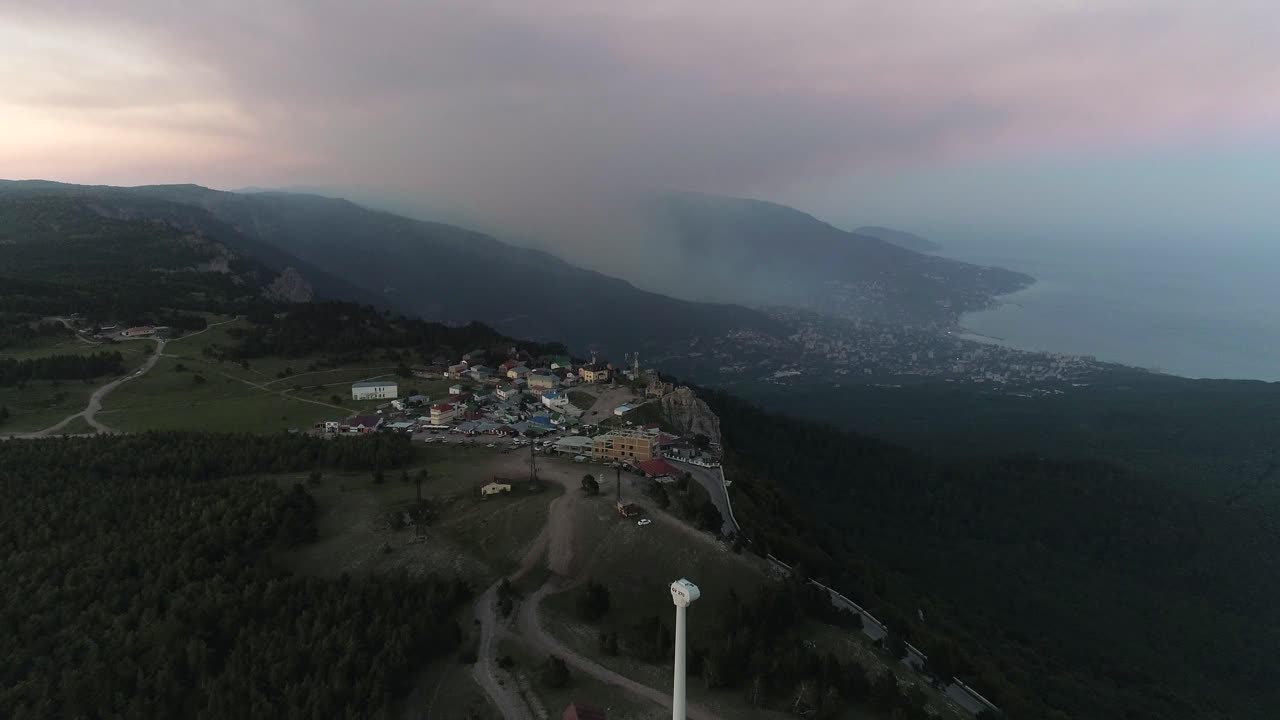 해가 지는 산악 도시 와 해안선 의 공중 사진