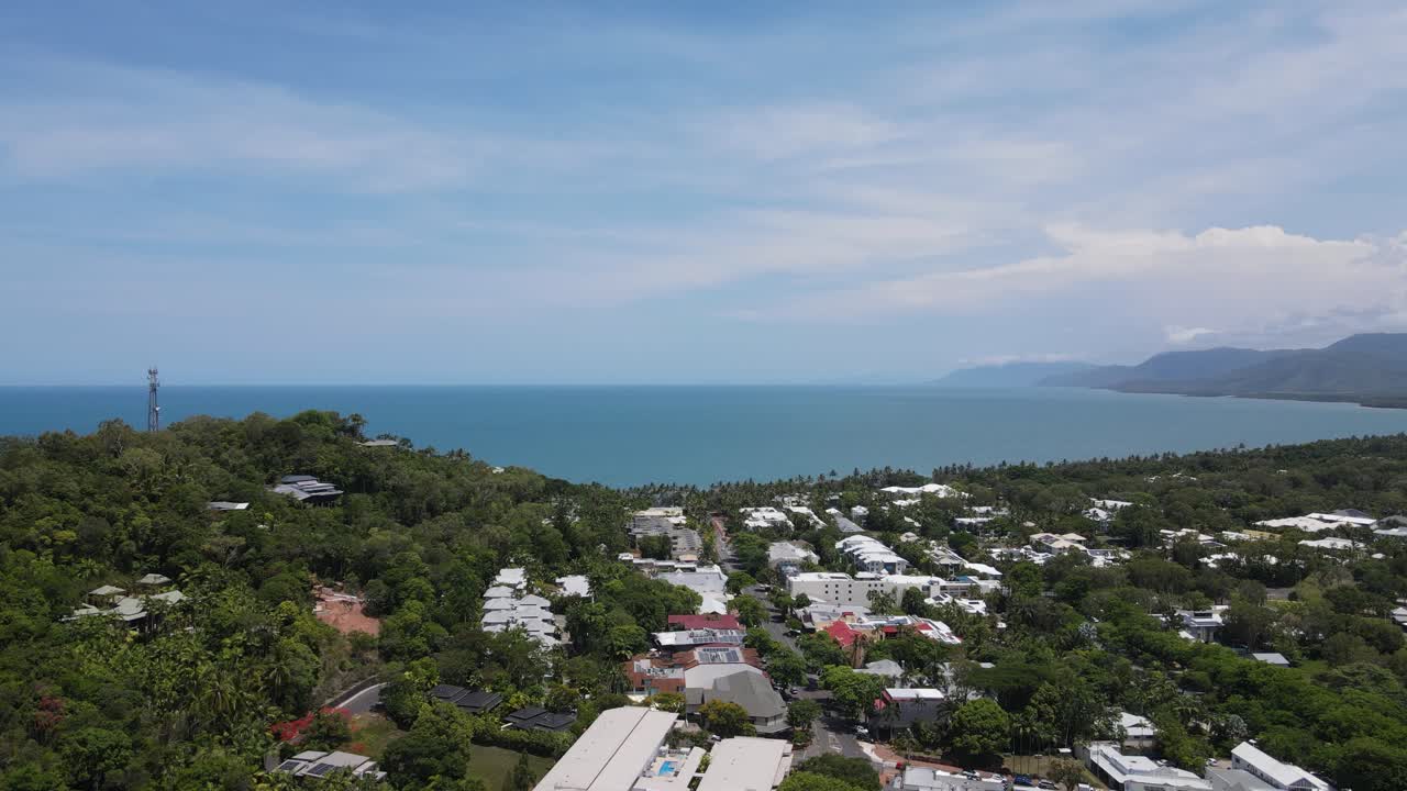 revelando la vista de un avión no tripulado sobre la ciudad australiana de port douglas mirando hacia la ciudad de cairns en la distancia