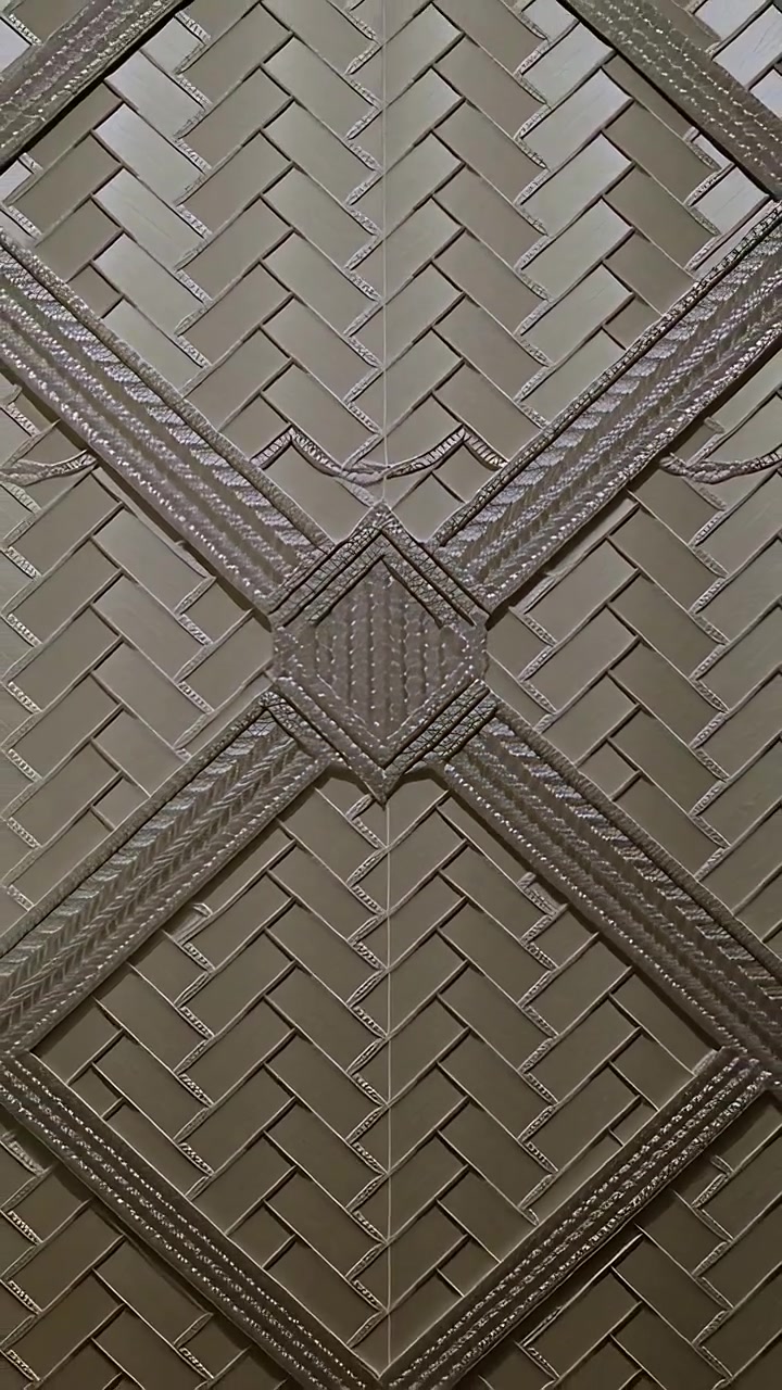 Vertical video: Shifting frame moving camera sliding herringbone panel on wall showing loose braid