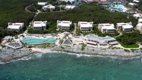 beautiful aerial drone view of the tropical coastline of playa del carmen with large vacation resorts with pools and bars in riviera maya, mexico on a warm sunny summer day