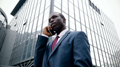 busy black  businessman on the street talking with smartphone