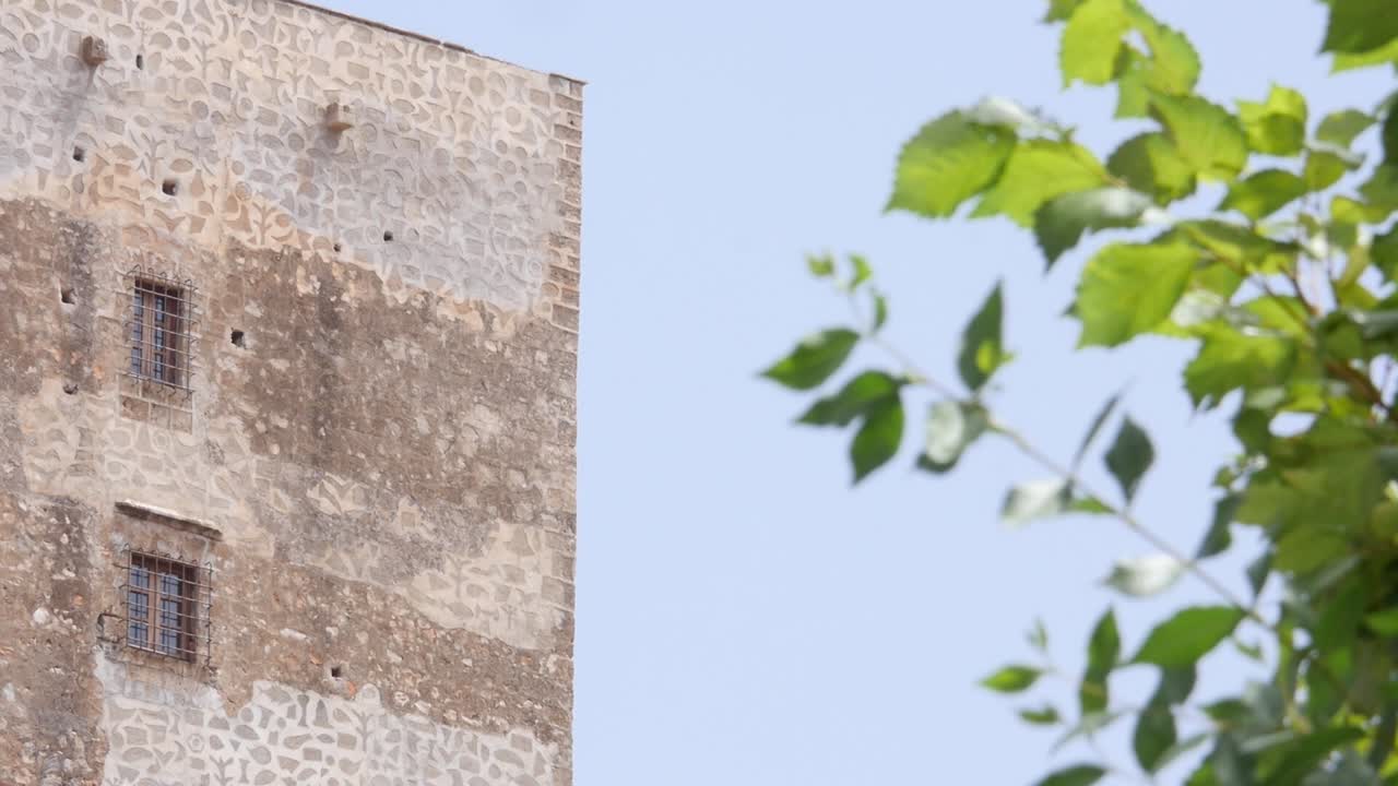 Mura in pietra e finestre sbarrate della Torre Nasrid a Vélez de Benaudalla, Granada. Architettura difensiva andalusa medievale
