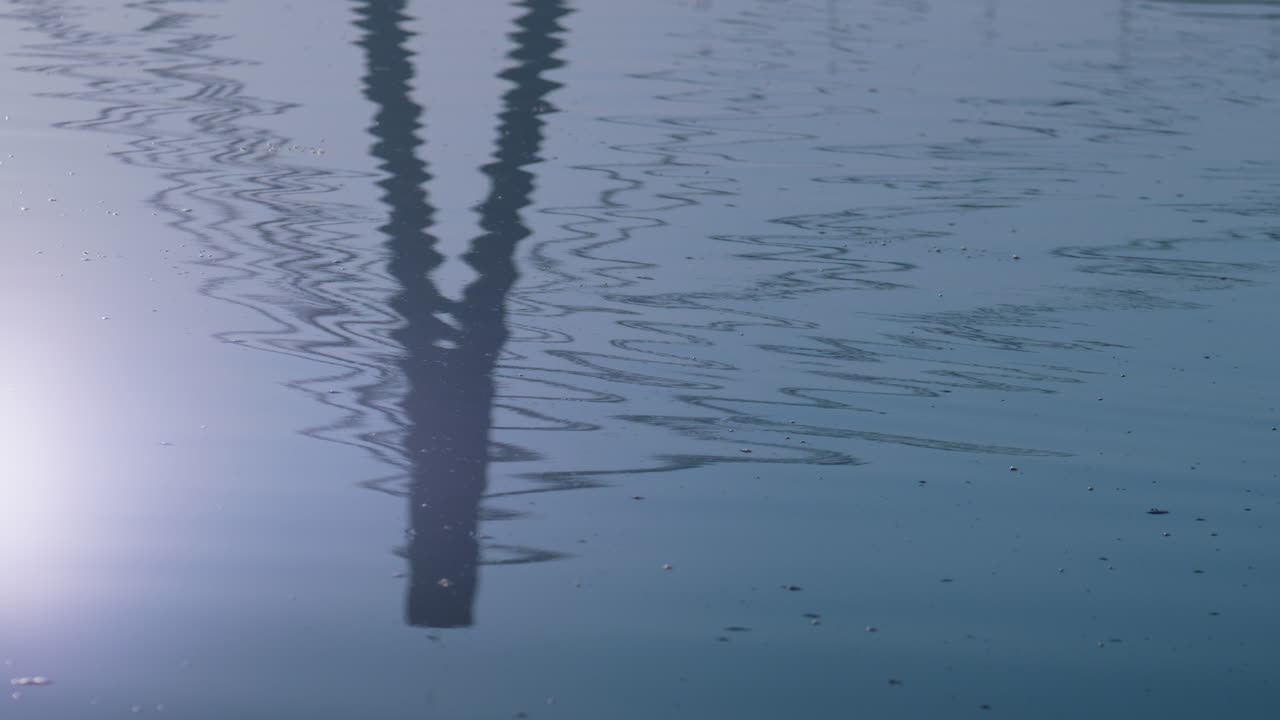 Lake surface reflect bridge autumn day. Silhouette modern tower on water.