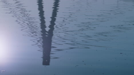 Seeoberfläche-Spiegelt-Brücke-Herbsttag-Wider.-Silhouette-Moderner-Turm-Auf-Dem-Wasser.