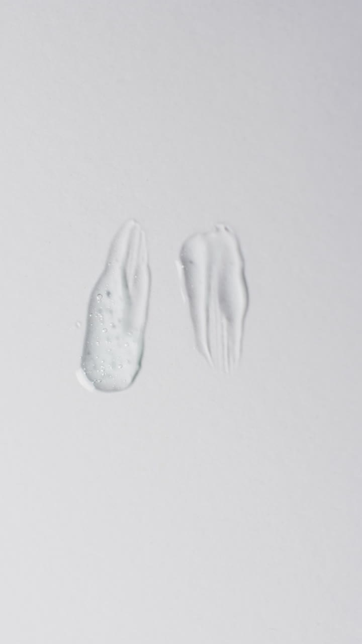 Vertical video of beauty product cream smudges with copy space on white background