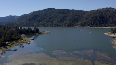 Una-Hermosa-Toma-Aérea-Con-Un-Dron-Que-Asciende-Sobre-El-Gran-Lago-Del-Oso-Volando-Hacia-El-Horizonte-De-La-Montaña-En-El-Condado-De-San-Bernardino,-California