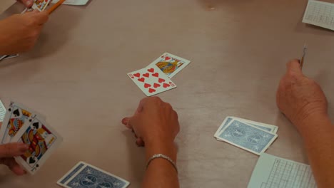 close-up of the hands of four people playing a card game