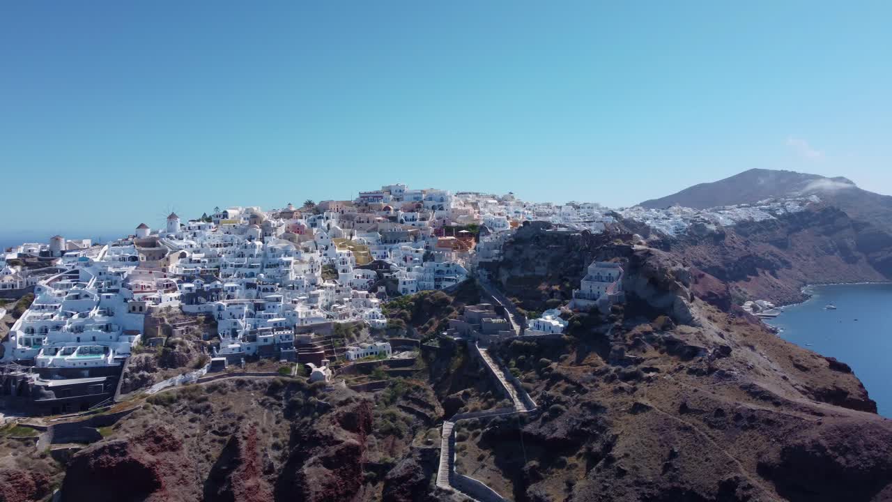 vuelo sobre las tradicionales villas blancas adosadas ini village oia, santorini, grecia