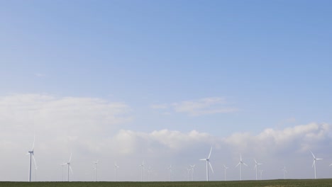 molinos de viento en un campo verde con un hermoso cielo - amplio plano