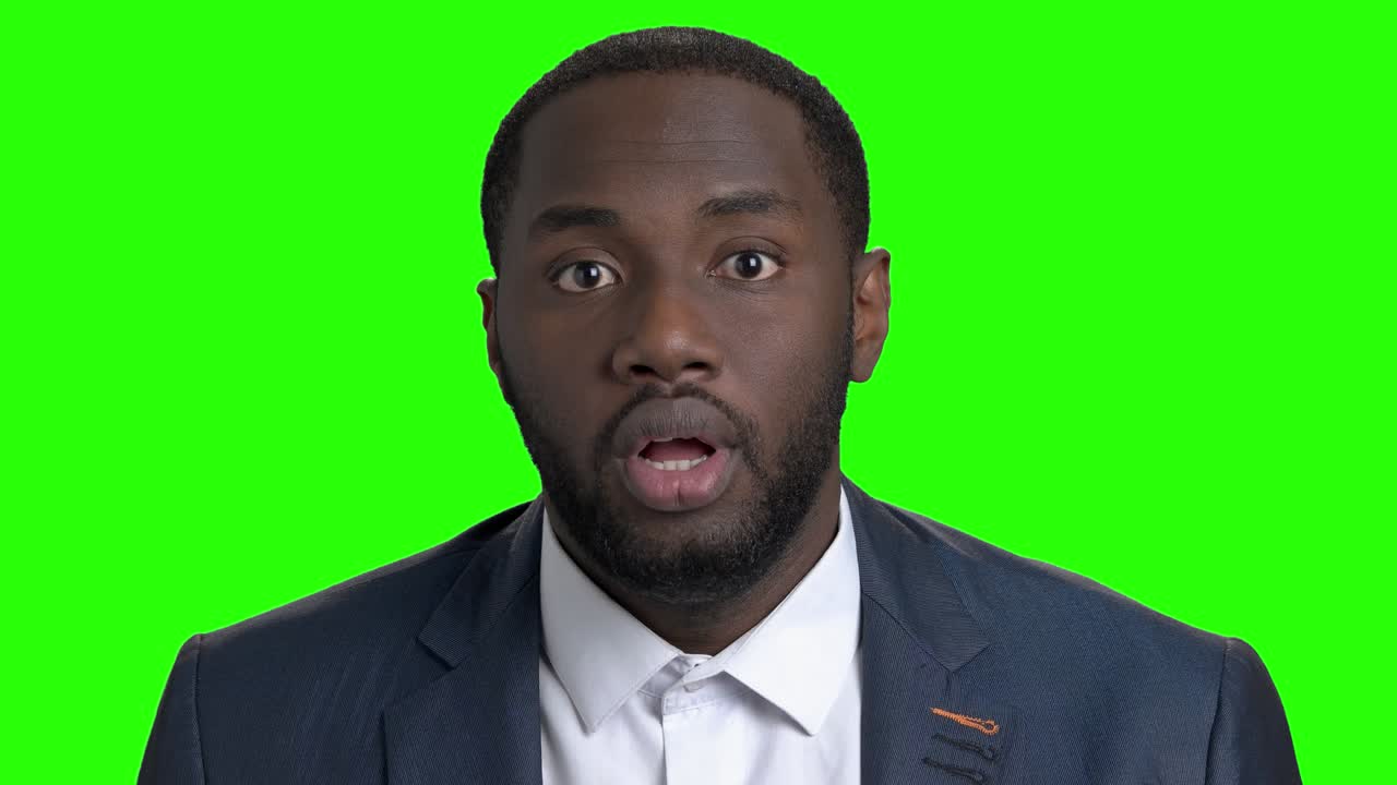 Shocked afro american businessman on green screen.