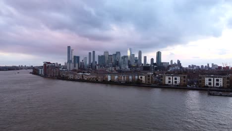 Canary-Wharf-skyline-in-London-from-over-the-River-Thames,-aerial-view