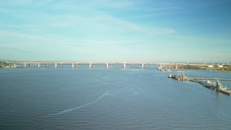 aerial wide pan across bridges to marine infrastructure along carquinez strait regional shoreline wetlands in martinez, california