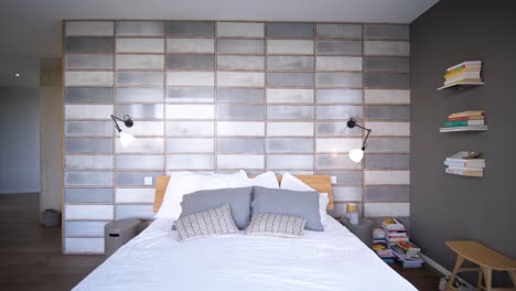 Slow-pull-out-shot-showing-a-grey-master-bedroom-with-bookshelves-in-a-villa