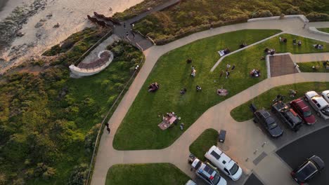 people admiring sunset on promontory of surfers point beach, prevelly area in western australia