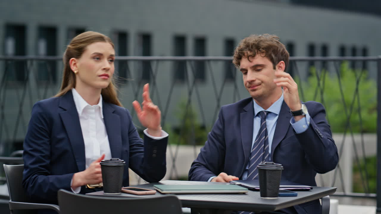 Frustrated businesspeople closing laptop reacting on bad news outdoors closeup