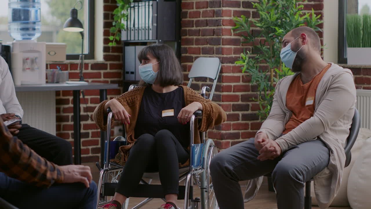 Woman with disability attending aa group therapy session with people in circle