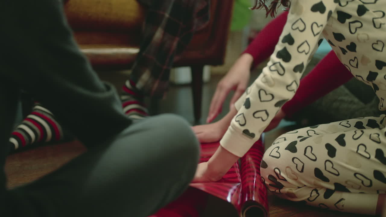 A family wrapping Christmas gifts